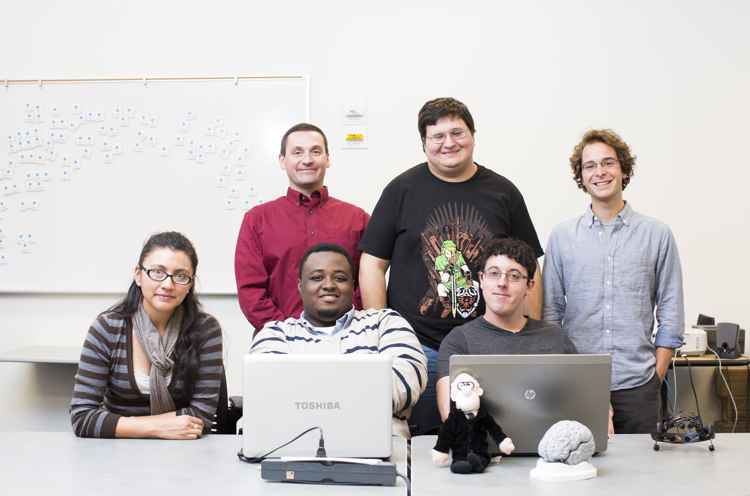 Group of students and faculty sitting with laptops.