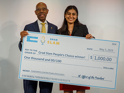 UC President Michael Drake and Aneelman Brar holding big check