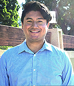 Male with brown hair wearing a blue shirt