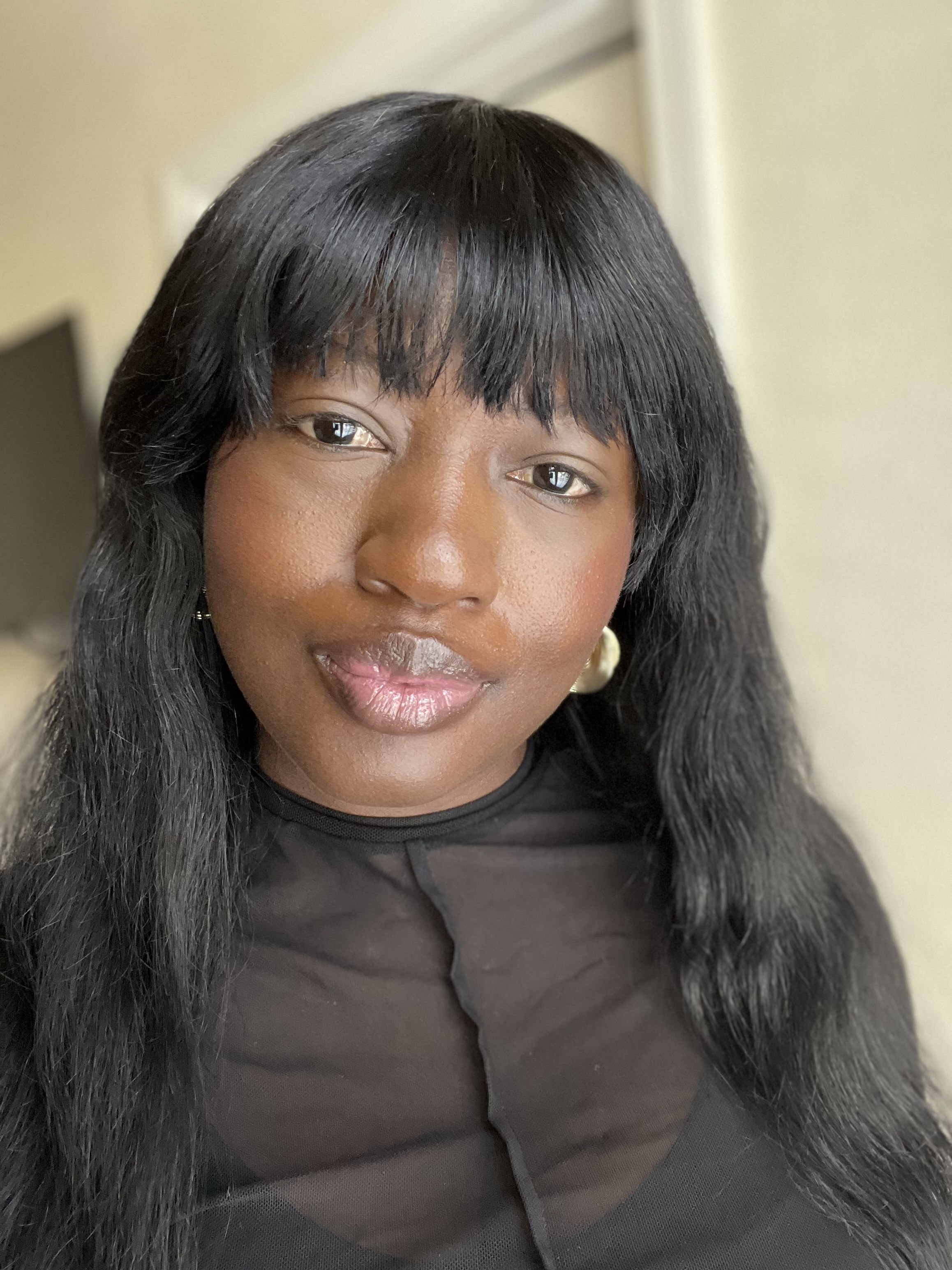 Black woman with black hair wearing a black blouse