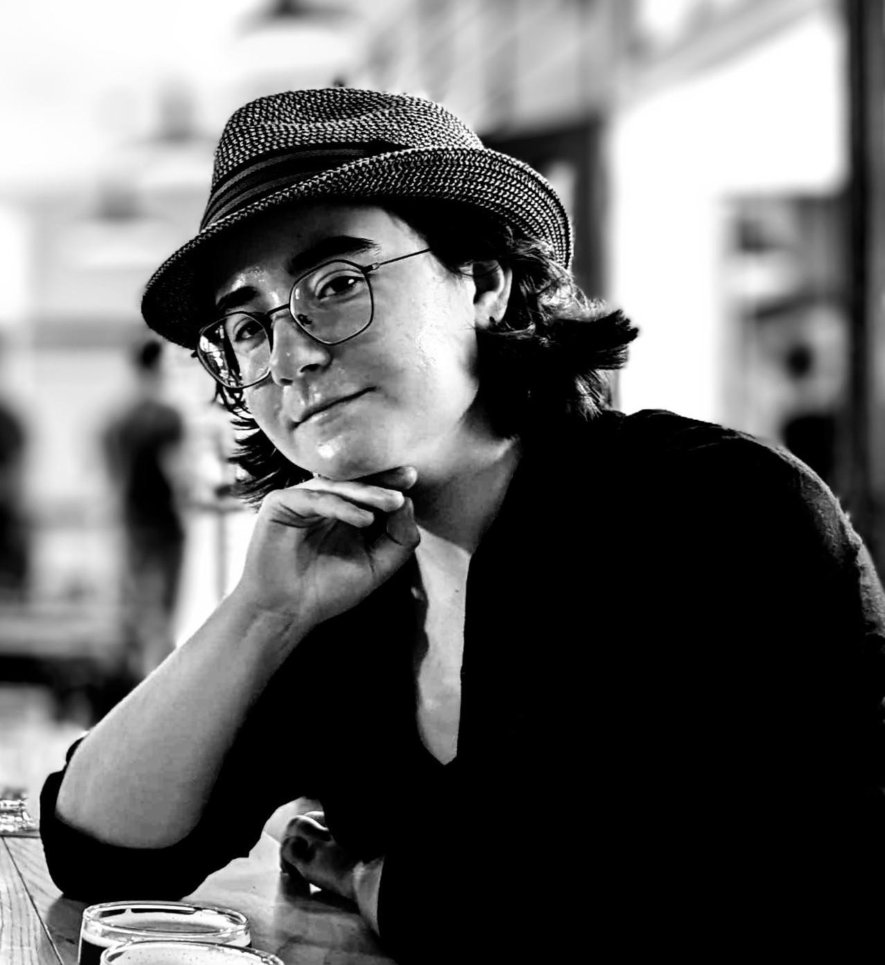 Individual wearing black shirt, glasses and hat