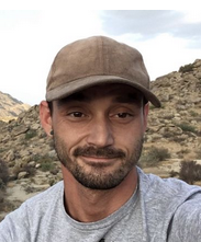 male with beard wearing tan baseball cap and gray t-shirt