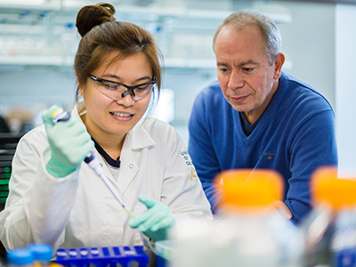 Professor Victor Munoz and student pipetting in a lab