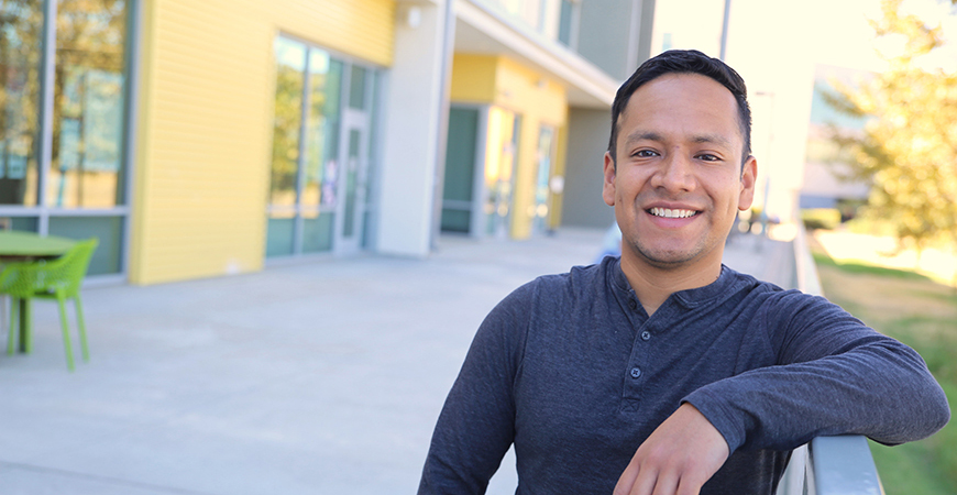 Andres Arias standing in front of campus building
