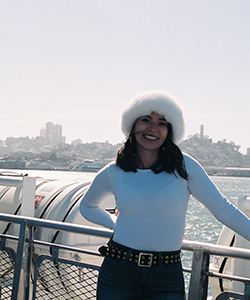 Female wearing white top and white hat in front of skyline