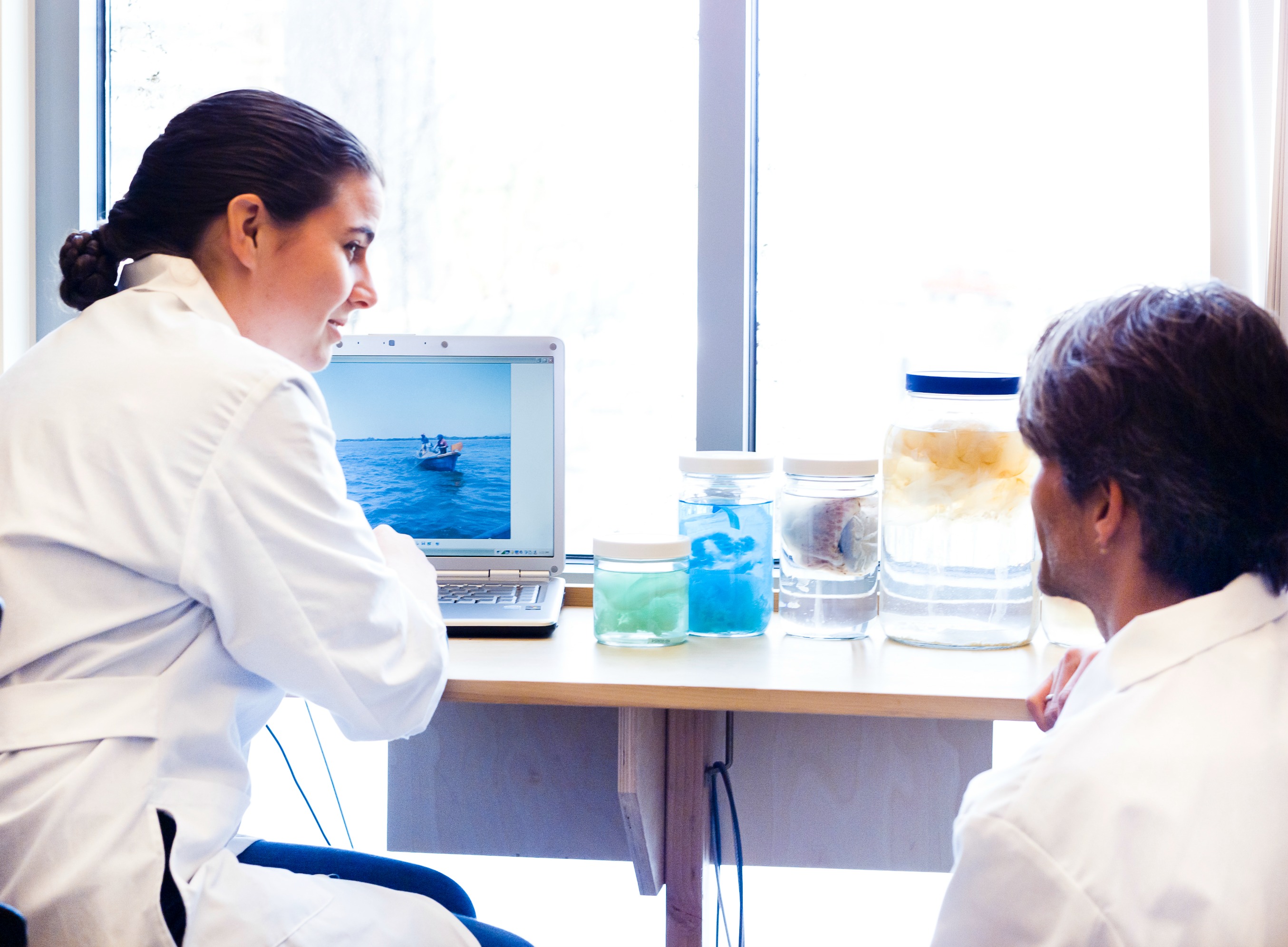 Two students in lab coats working on research