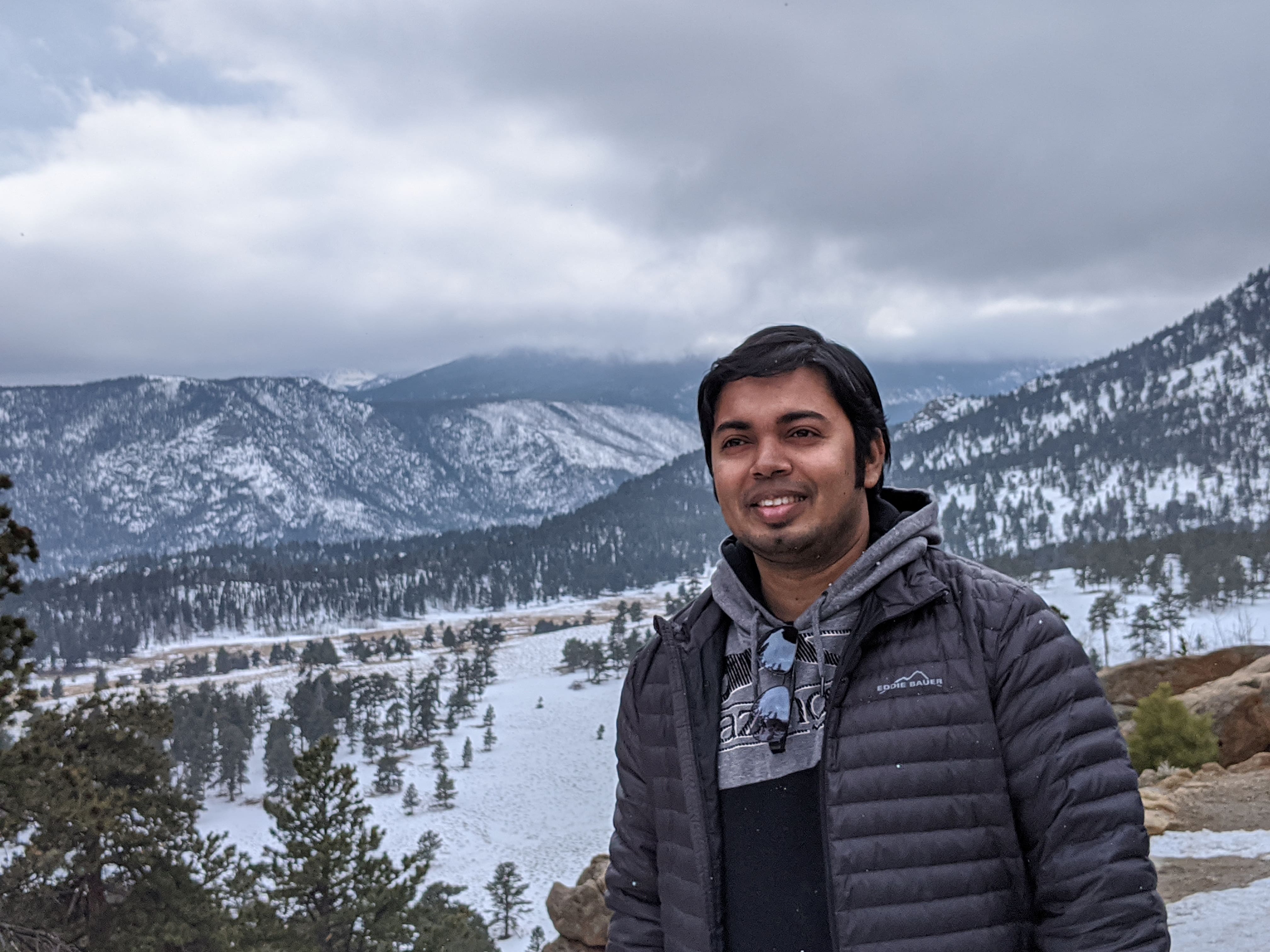 male student wearing  gray jacket in snowy mountains