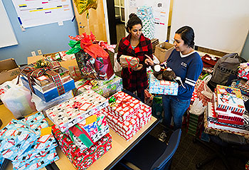 Student interns sort gifts for A Home for the Holidays, an outreach program that supports All Dads Matter. 