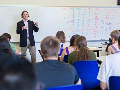 Professor Kurt Schnier  lecturing a class in front of whiteboard