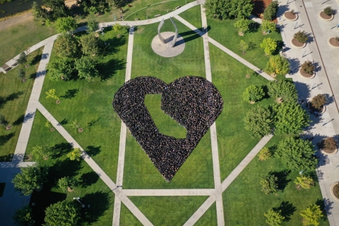 UC Merced quad with students forming a heart